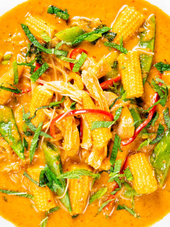 Close-up overhead Thai chicken noodle soup with sugar snap peas and baby corn.