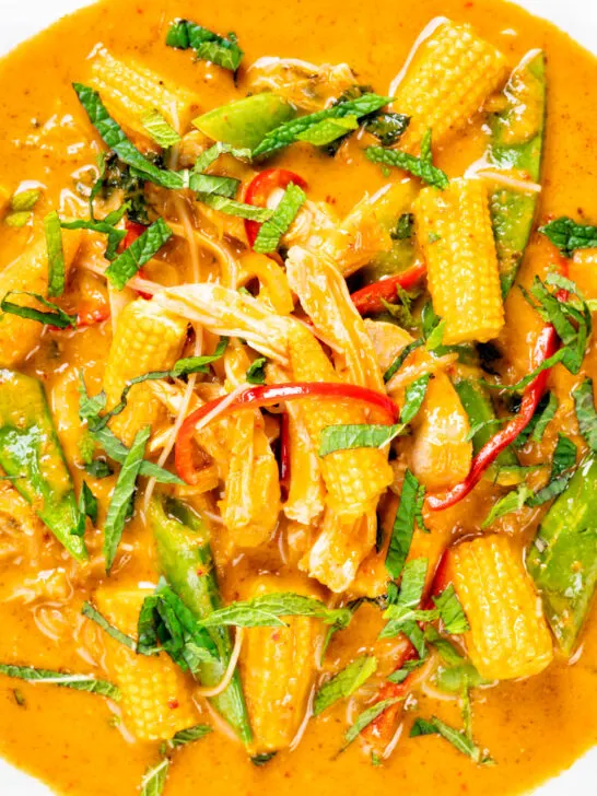 Close-up overhead Thai chicken noodle soup with sugar snap peas and baby corn.