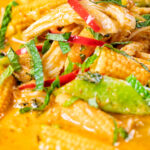 Close-up overhead Thai chicken noodle soup with sugar snap peas and baby corn.