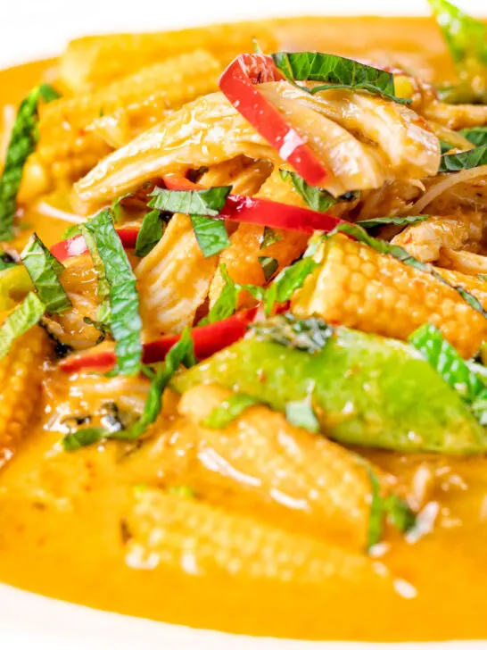 Close-up overhead Thai chicken noodle soup with sugar snap peas and baby corn.