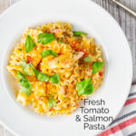 Overhead tomato and salmon fillet pasta with basil and crispy bread crumbs featuring a title overlay.