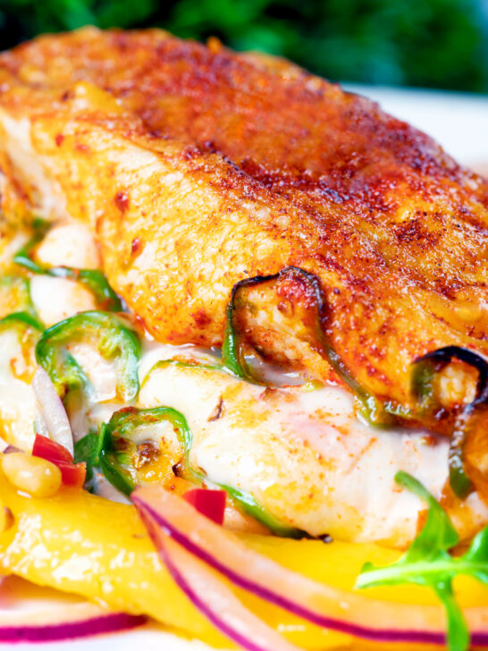 Close-up air fryer stuffed chicken breast with mozzarella cheese and jalapeno chilli peppers.