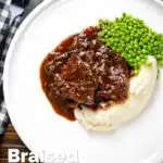 Overhead braised steak and onions served with mashed potato and peas featuring a title overlay.