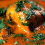 Close-up chicken chasni curry with fresh coriander.