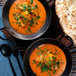 Overhead chicken chasni curry served with naan bread.