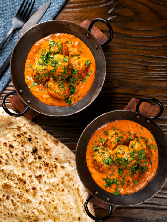Overhead Indian chicken kofta or meatball curry served with naan bread.