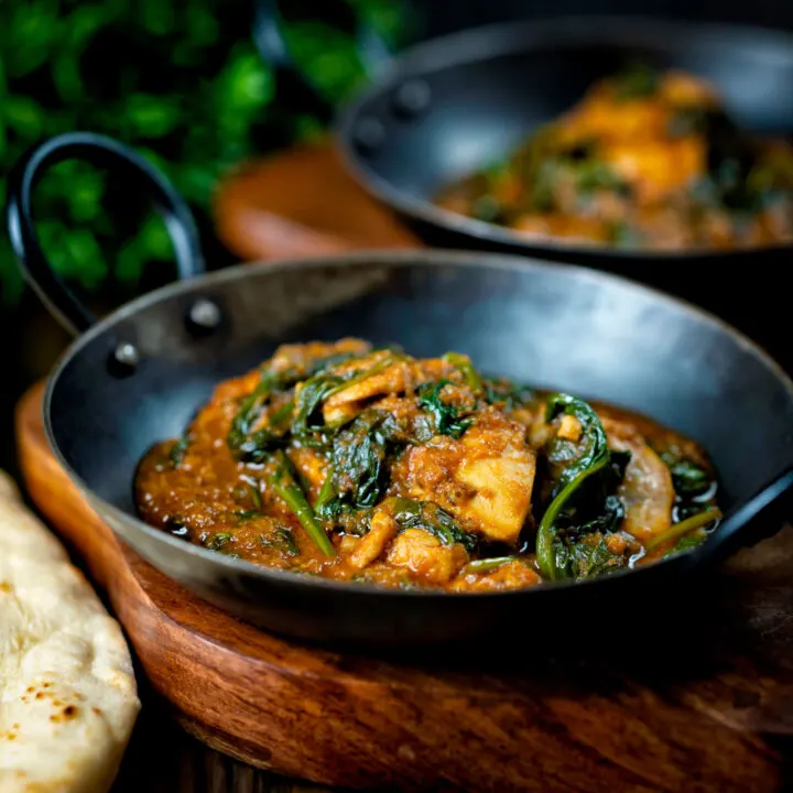 Chicken saag or saagwala curry served in iron karai bowls.