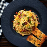 Overhead Spanish chorizo sausage and shredded leek pasta.