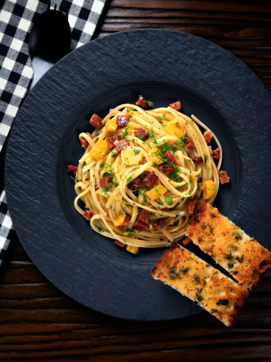 Overhead Spanish chorizo sausage and shredded leek pasta.