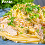 Close-up creamy lemon chicken pasta with capers and parsley featuring a title overlay.