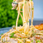Creamy lemon chicken pasta being picked up with a fork.