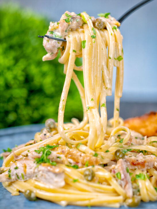 Creamy lemon chicken pasta being picked up with a fork.