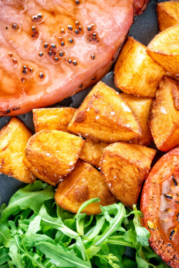 Crispy fried or sauteed potatoes served with bacon chop, grilled tomato and rocket.