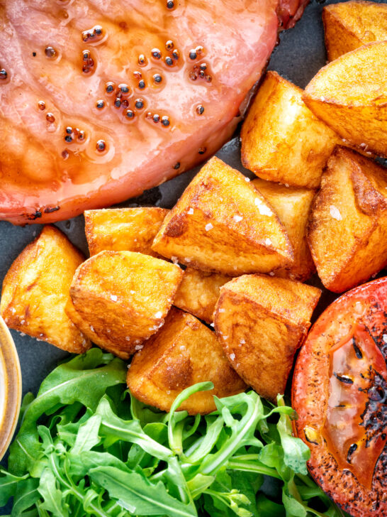 Crispy fried or sauteed potatoes served with bacon chop, grilled tomato and rocket.