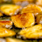 Close-up crispy fried potatoes being cooked in oil.