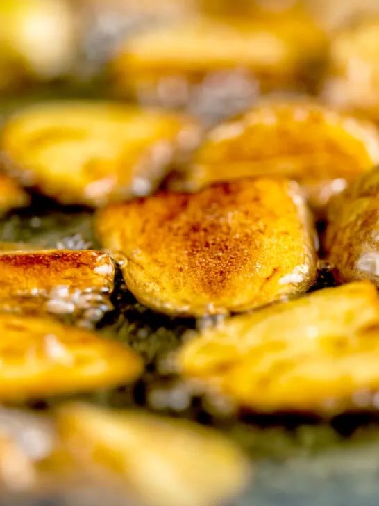 Close-up crispy fried potatoes being cooked in oil.