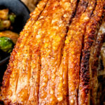 Close up crispy crackling on a slow roasted pork belly joint.