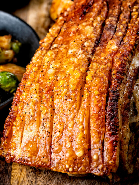 Close up crispy crackling on a slow roasted pork belly joint.