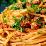 Close-up crumbled tofu pasta in a spiced tomato sauce.