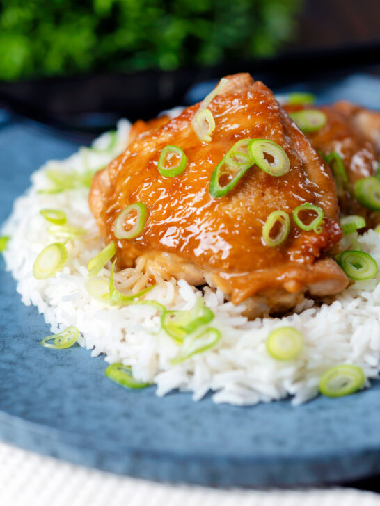 Filipino coconut milk chicken thigh adobo served with white rice featuring a title overlay.