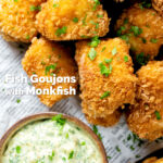 Close-up overhead fish goujons or nuggets made with monkfish served with tartar sauce featuring a title overlay.