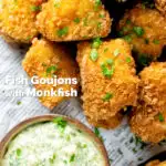 Close-up overhead fish goujons or nuggets made with monkfish served with tartar sauce featuring a title overlay.