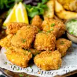 Fish goujons or nuggets made with monkfish served with tartar sauce and wedges.