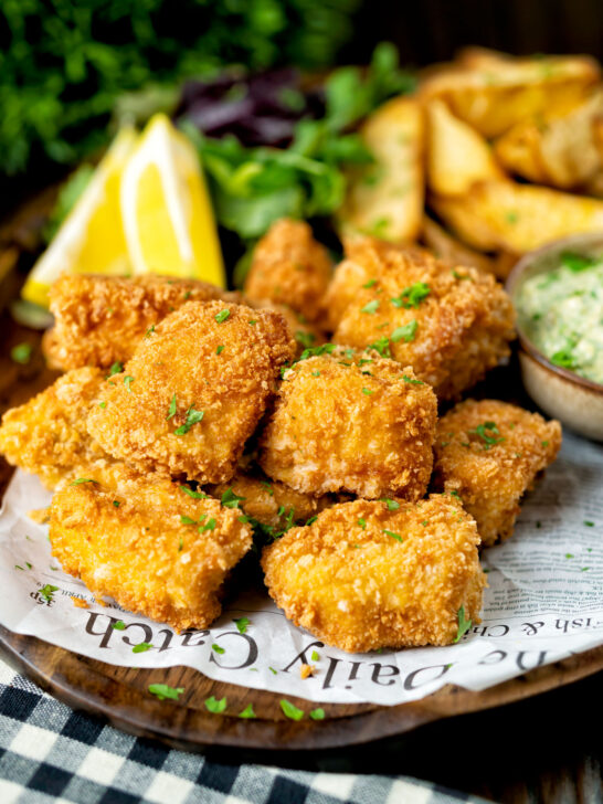 Fish goujons or nuggets made with monkfish served with tartar sauce and wedges.