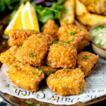 Fish goujons or nuggets made with monkfish served with tartar sauce and wedges featuring a title overlay.