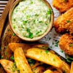 Overhead homemade tartar sauce served with wedges and fish goujons.
