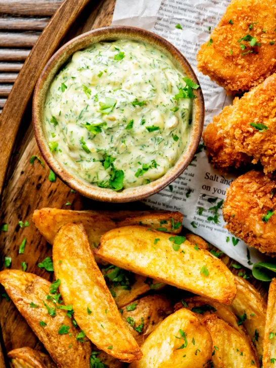 Overhead homemade tartar sauce served with wedges and fish goujons.