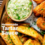 Overhead homemade tartar sauce served with wedges and fish goujons featuring a title overlay.