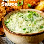 Close-up homemade tartar sauce served with fish goujons and potato wedges featuring a title overlay.