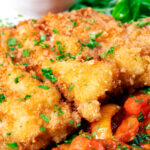 Close-up kotlet schabowy (Polish pork schnitzel) served with lecso.