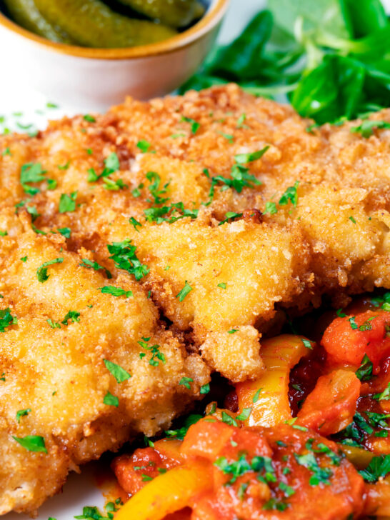 Close-up kotlet schabowy (Polish pork schnitzel) served with lecso.