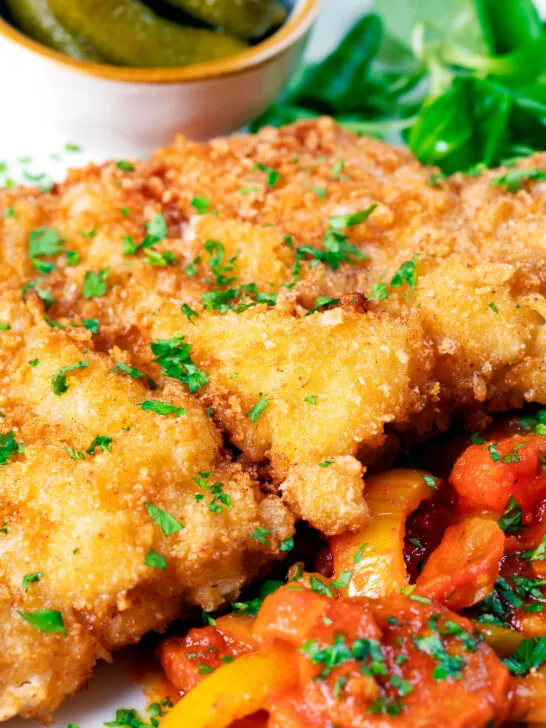 Close-up kotlet schabowy (Polish pork schnitzel) served with lecso.