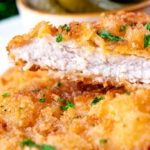 Close-up kotlet schabowy cut open to show the juicy tender pork meat.
