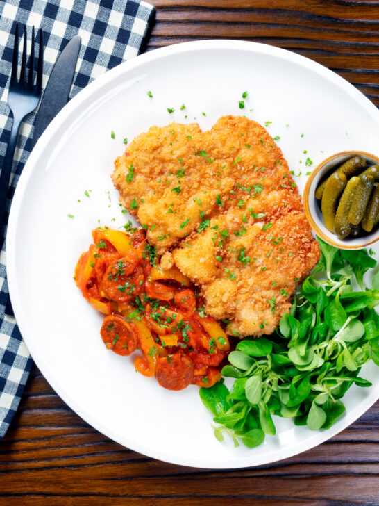 Overhead kotlet schabowy (Polish pork schnitzel) with Hungarian lecsó.