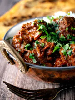 Lamb rogan josh curry with rice, naan and fresh coriander.