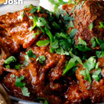 Close-up lamb rogan josh curry with rice and fresh coriander featuring a title overlay.