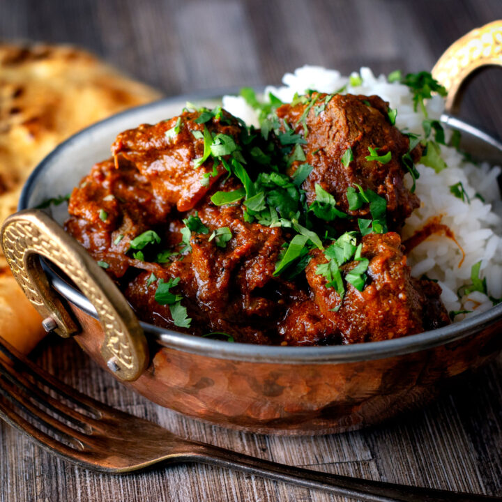 Kashmiri influenced lamb rogan josh curry served with rice and naan bread.