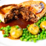 Homemade minced beef and onion pie cut open showing the filling.