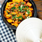 Overhead butternut squash tagine served in a tagine pot.