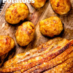 Overhead roast potatoes served along side roasted pork belly with crispy crackling featuring a title overlay.