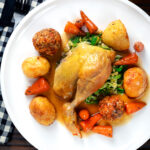 Overhead roast chicken served with all of the trimmings as part of a Sunday lunch.