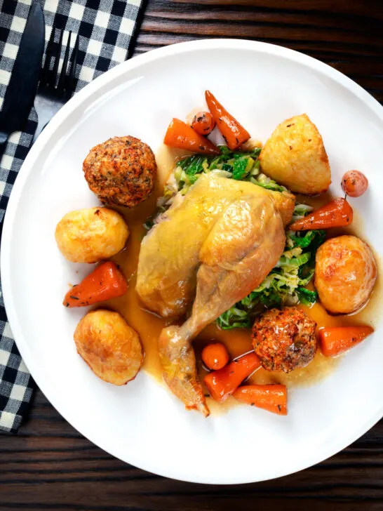 Overhead roast chicken served with all of the trimmings as part of a Sunday lunch.