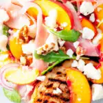 Close-up overhead main course summer salad with pickled peaches, ham and goats cheese featuring a title overlay.