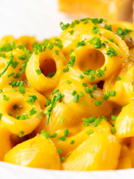 Close-up roasted butternut squash pasta garnished with snipped chives.