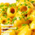 Close-up roasted butternut squash pasta garnished with snipped chives featuring a title overlay.