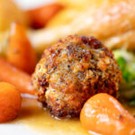 Close-up sage and onion stuffing balls as part of a Sunday lunch dinner.